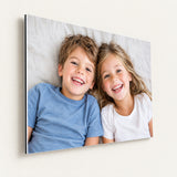 Foto op aluminium wit met een lachende broer en zus op bed, strakke witte rand