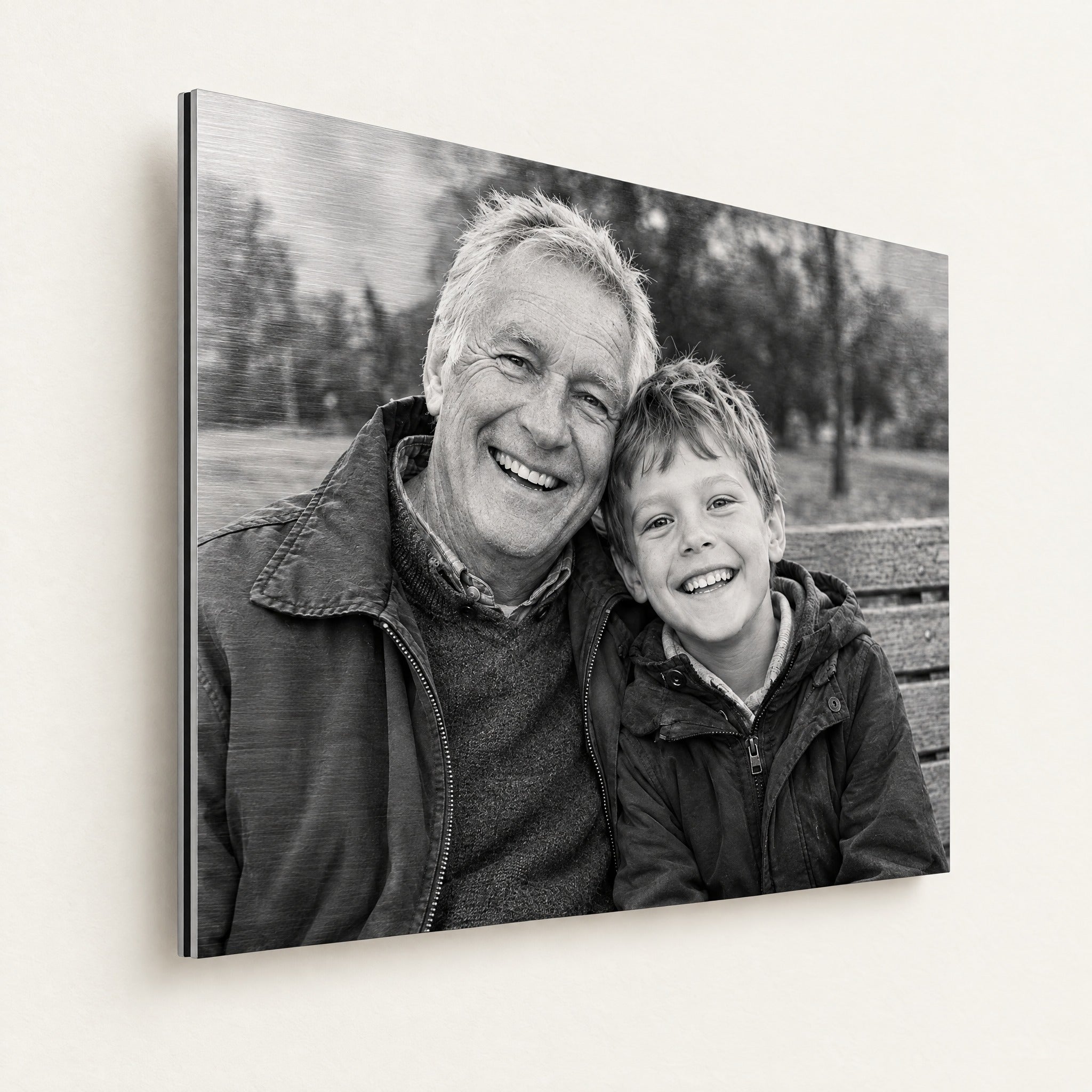 Zwart-witfoto op geborsteld aluminium met opa en kleinzoon, subtiele metaalstructuur