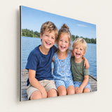 Foto op fine-art aluminium (Dibond) met drie lachende kinderen op een steiger, matte afwerking