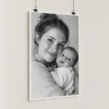 Zwart-witfoto op fine-art papier met moeder en baby, aan zwarte posterclips