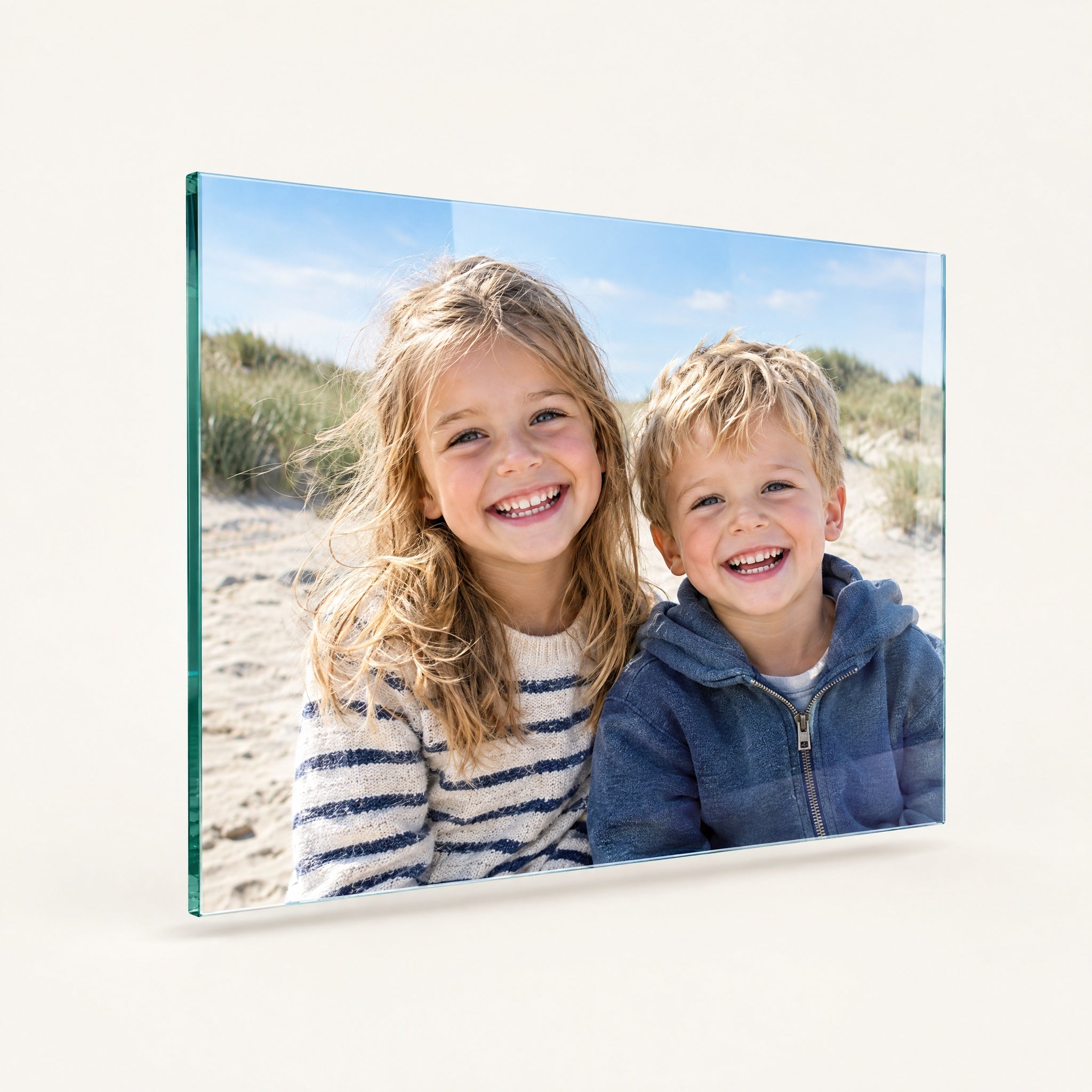 Foto op glas met een lachende broer en zus op het strand, gepolijste glasrand zichtbaar