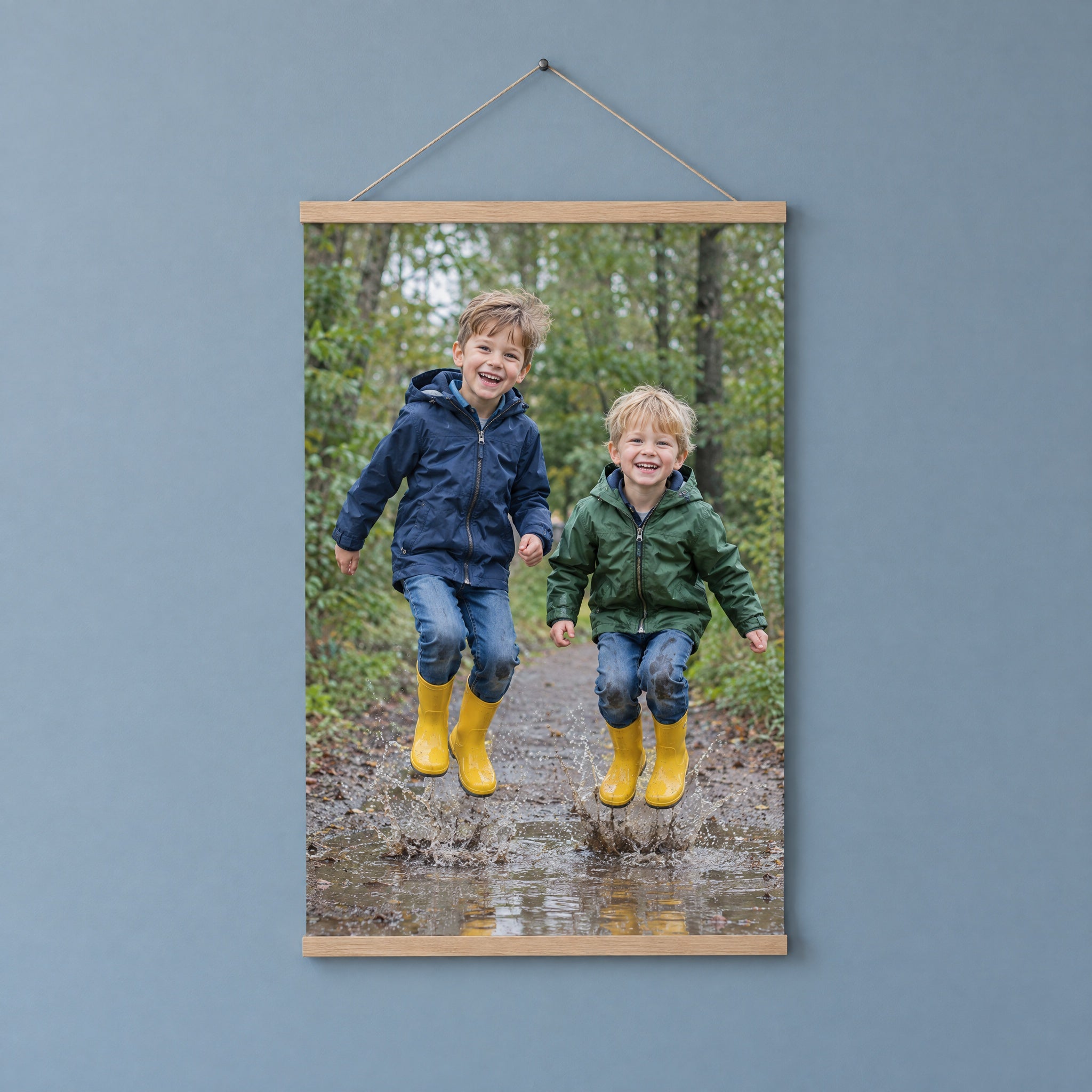 Foto auf Poster in einer Holz-Posterleiste mit zwei Brüdern, die in eine Pfütze springen